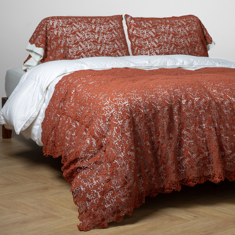 Allora Bed Scarf | Autumn | a three-quarter angle of a full bed dressed in white with an all-over lace bed scarf and matching pillow covers in Autumn, a rich terracotta tone.