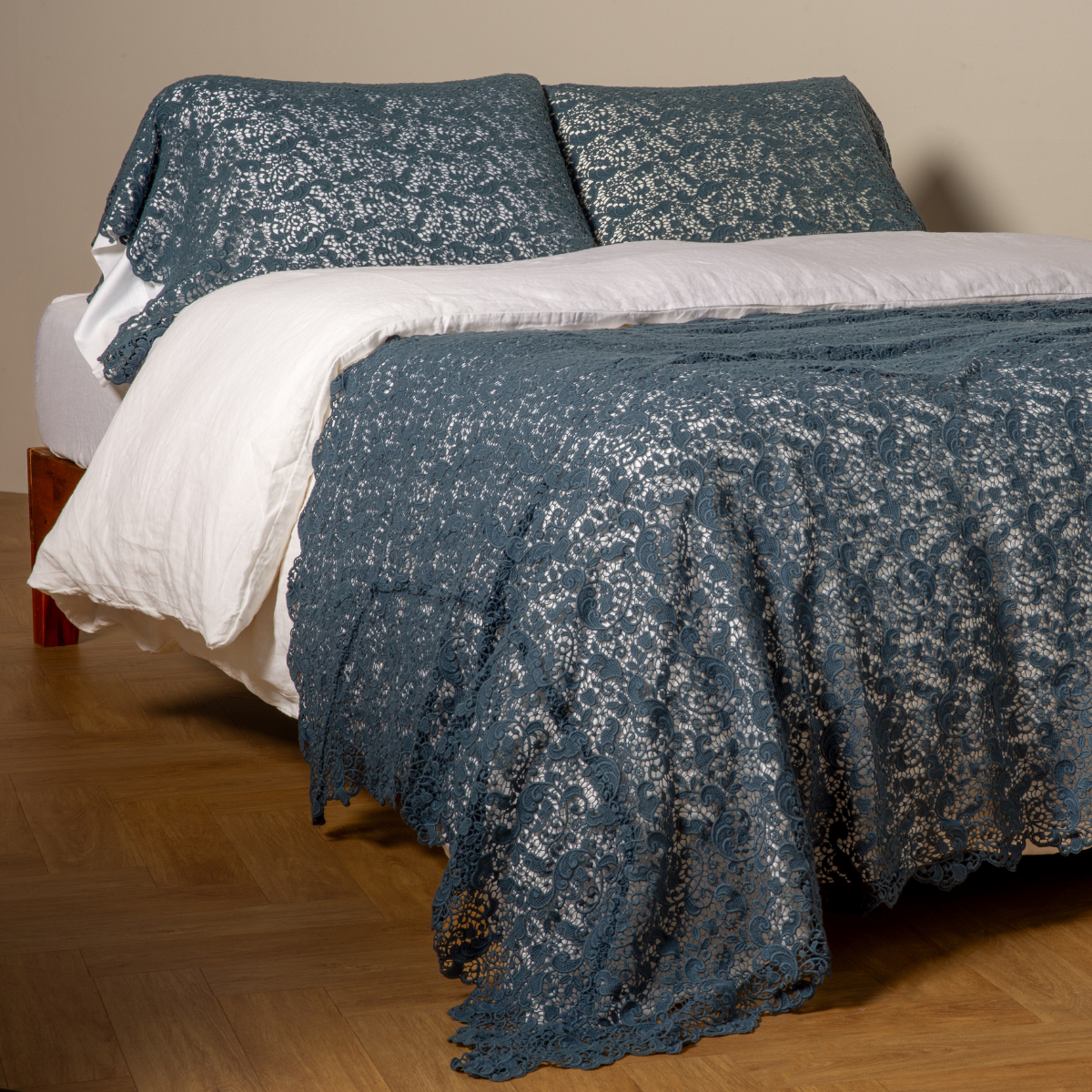 Allora Bed Scarf | Midnight | cotton lace bed scarf draped across the foot of a bed dressed in linen sheets and duvet cover in winter white -  shown with matching lace pillowcase covers over a linen liner in winter white.