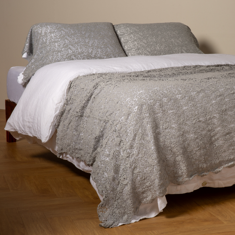 Allora Bed Scarf | Mineral | cotton lace bed scarf draped across the foot of a bed dressed in linen sheets and duvet cover in winter white -  shown with matching lace pillowcase covers over a linen liner in winter white.