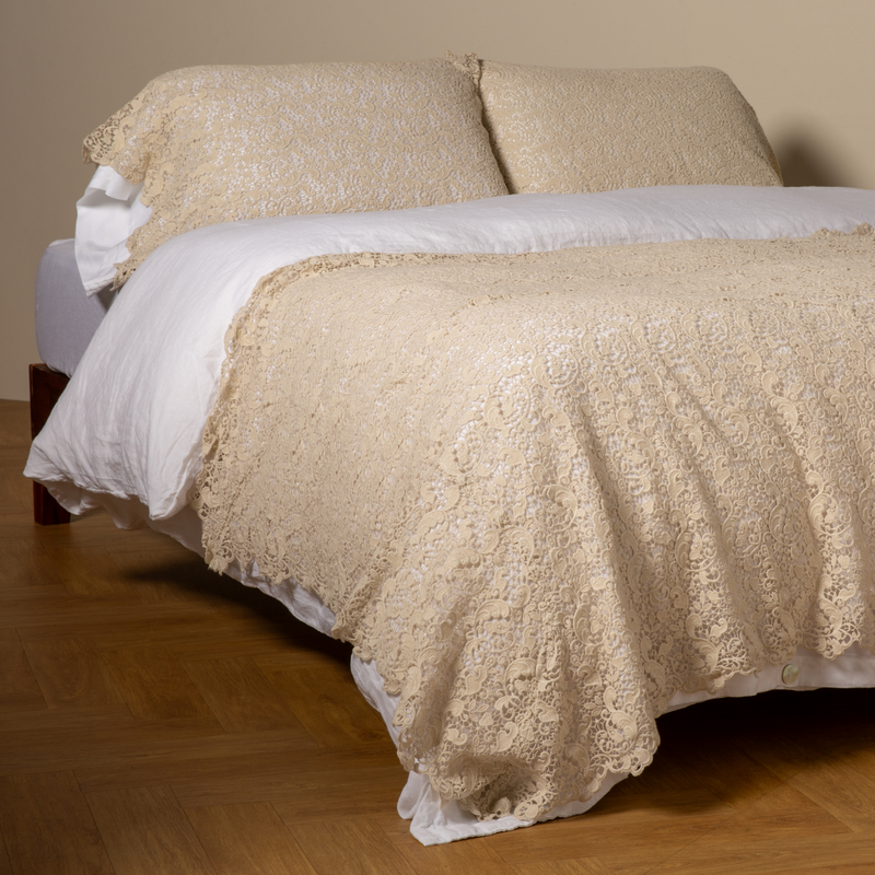 Allora Bed Scarf | Parchment | cotton lace bed scarf draped across the foot of a bed dressed in linen sheets and duvet cover in winter white -  shown with matching lace pillowcase covers over a linen liner in winter white.