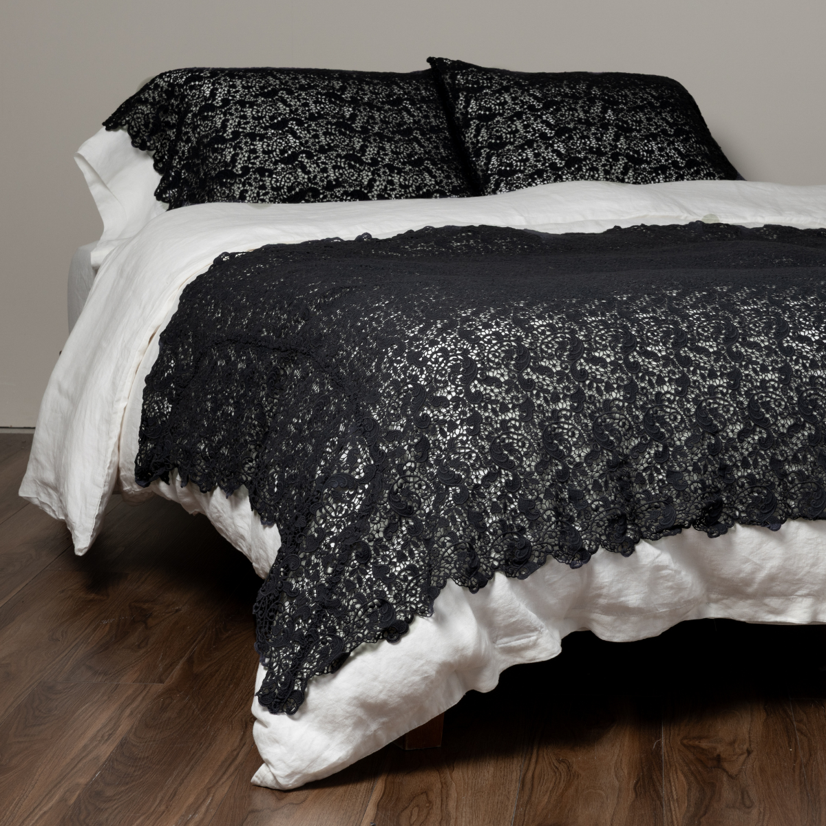 Allora Bed Scarf | Slate | Matching cotton lace bed scarf throw blanket and matching pillowcases on a plain white bed shown a a 3/4 angle from the foot.