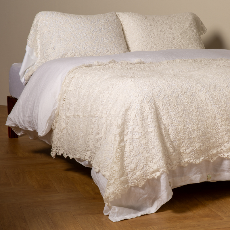 Allora Bed Scarf | Winter White | cotton lace bed scarf draped across the foot of a bed dressed in linen sheets and duvet cover in winter white -  shown with matching lace pillowcase covers over a linen liner in winter white.