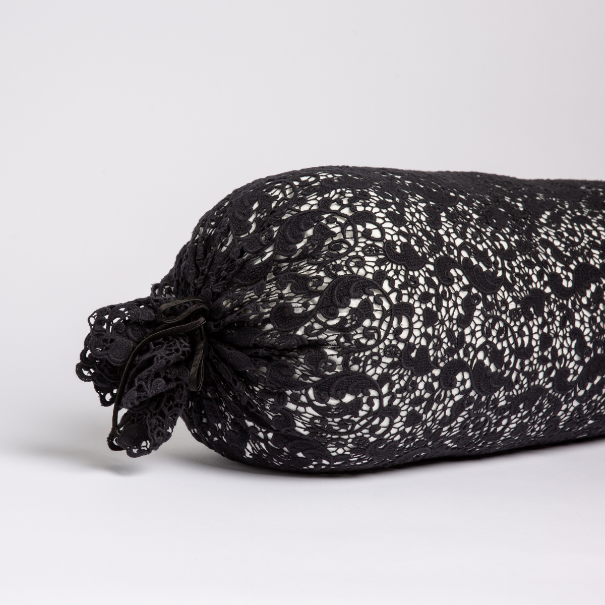 Allora Lace Throw Pillow | Corvino | one end of a lace boslter cover on a winter white liner against a white background.
