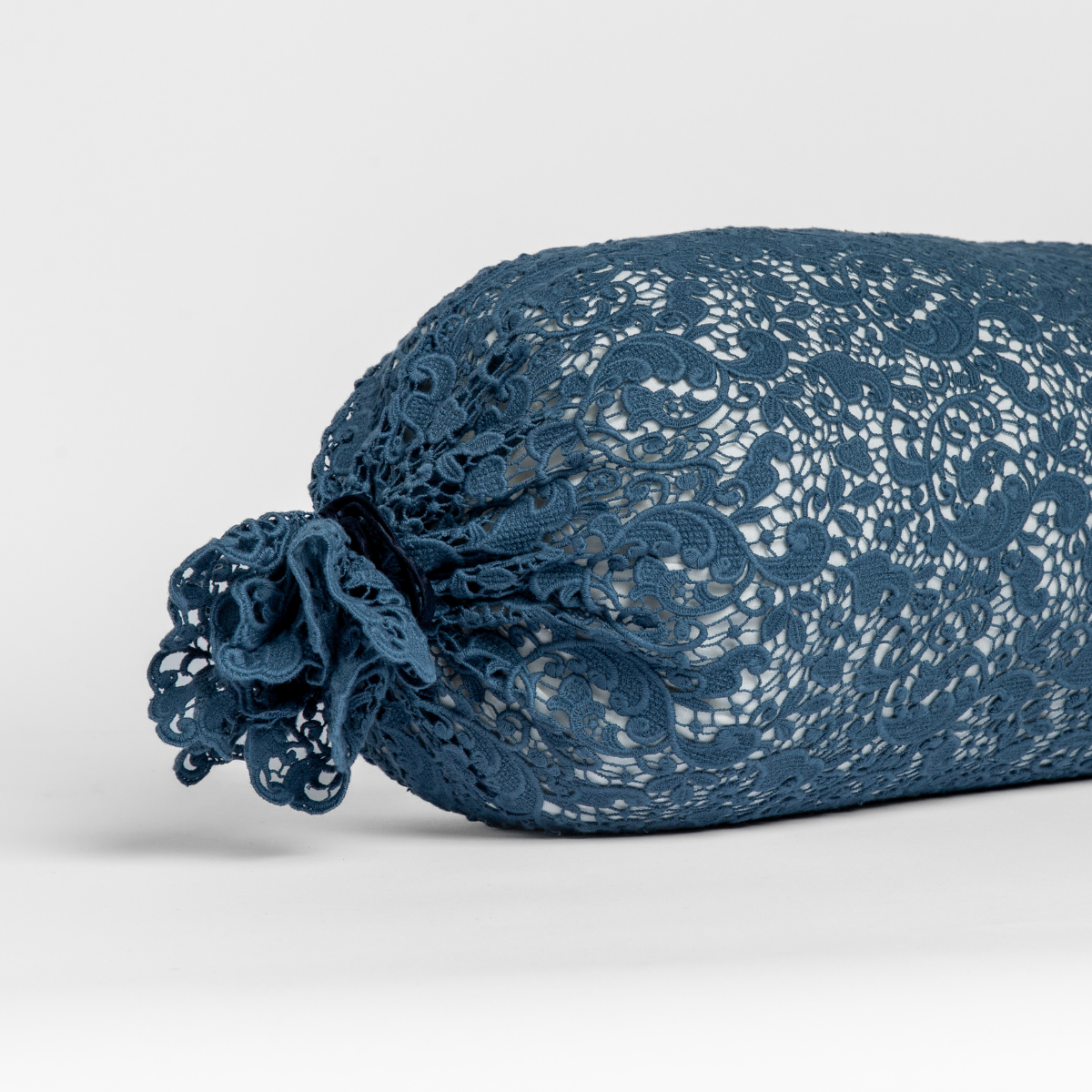 Allora Lace Throw Pillow | Midnight | one end of a lace boslter cover on a winter white liner against a white background.