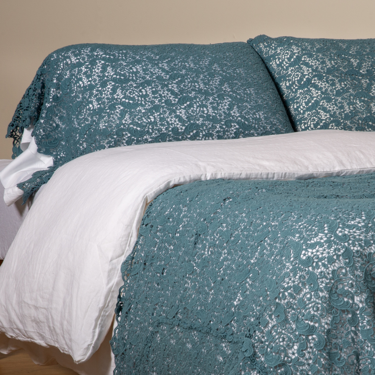 Allora Lace Pillowcase (Single) | Cenote | a pair of cotton lace pillowcase covers on winter white liners shown on a bed dressed in winter white linen with a matching cotton lace bed scarf.