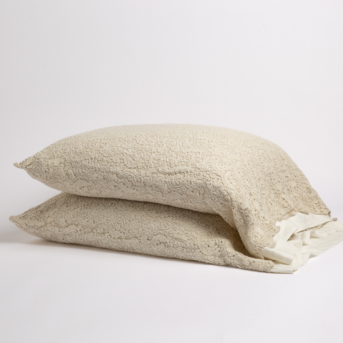 Allora Lace Pillowcase (Single) | Parchment | a pair of cotton lace pillowcase covers on winter white liners against a white background.