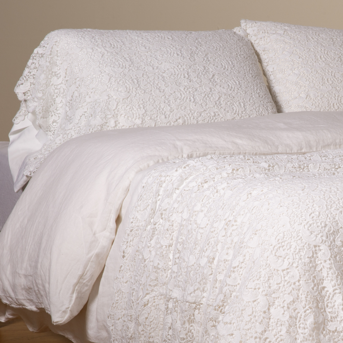 White: a pair of cotton lace pillowcase covers on winter white liners shown on a bed dressed in winter white linen with a matching cotton lace bed scarf. 