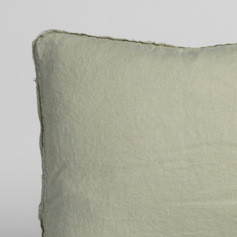Austin Sham | Desert Sage | close up of a pillow corner in desert sage, a serenely elegant green, offering a hushed hue, shown against a plain background.