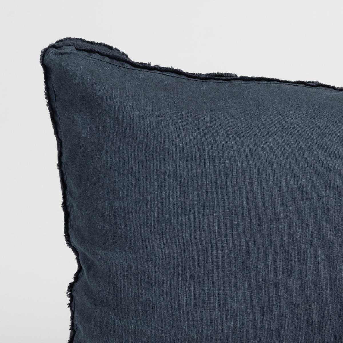 Slate | close-up of a austin sham corner in slate, a polished dusky dark blue, against a plain white background.