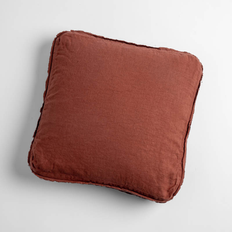 A close-up of an Austin Throw Pillow in Autumn, a rich terracotta tone, shown against a white background.