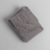 Austin Blanket - Holiday Release | Moonlight | a quilted midweight linen blanket folded  with a corner folded back - shot overhead against a white background.