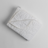 Austin Blanket - Holiday Release | White | a quilted midweight linen blanket folded  with a corner folded back - shot overhead against a white background.