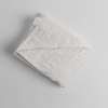 Austin Blanket - Holiday Release | Winter White | a quilted midweight linen blanket folded  with a corner folded back - shot overhead against a white background.