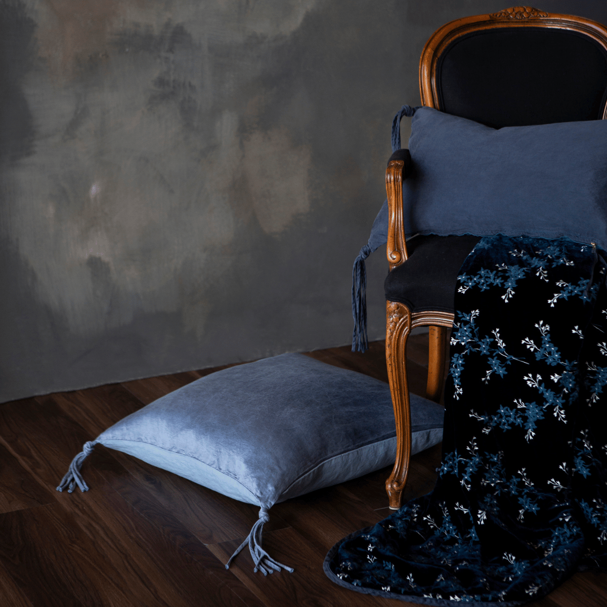 Lynette Blanket | Midnight | a throw pillow on a classic armchair with matching pillows from the taline collection.