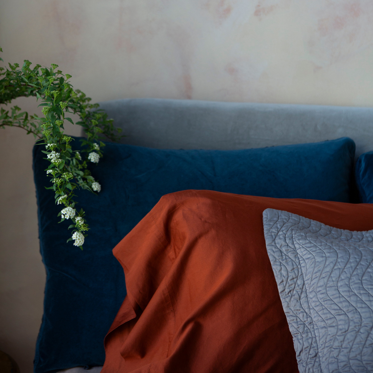 Bria Standard Pillowcase (Single) | a cotton sateen pillowcase shown between a quilted throw pillow and dark blue sham.