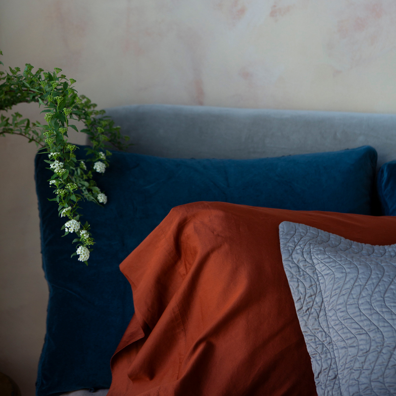Bria Standard Pillowcase (Single) | a cotton sateen pillowcase shown between a quilted throw pillow and dark blue sham.