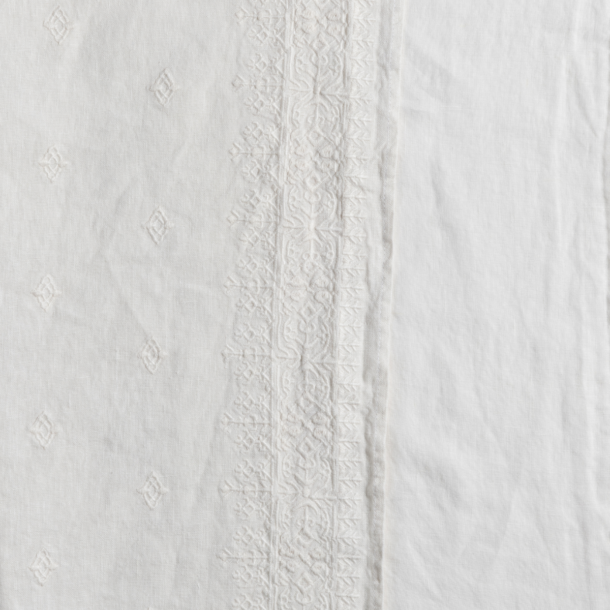 Ines Bedspread | Natural | a closeup of the band of embroidery on midweight linen in natural, a warm neutral.