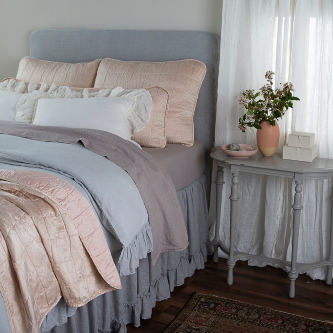 a bed dressed in linen with Sel shams, 18x54 inch throw pillow and throw blanket in pearl.