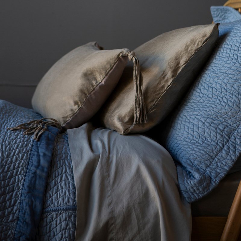 a 15x24 taline throw pillow in fog layered with a matching paloma pillowcase and cirillo shams in tahoe blue.