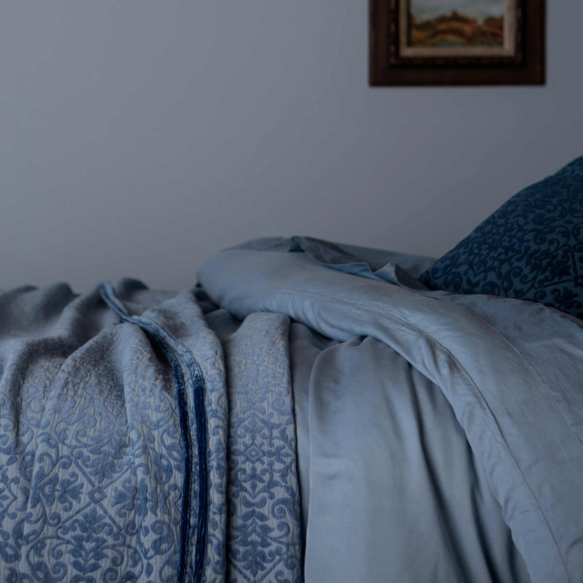 Vienna Twin Coverlet | Tahoe Blue | a coverlet layered over a duvet cover and flat sheet with matching pillows.