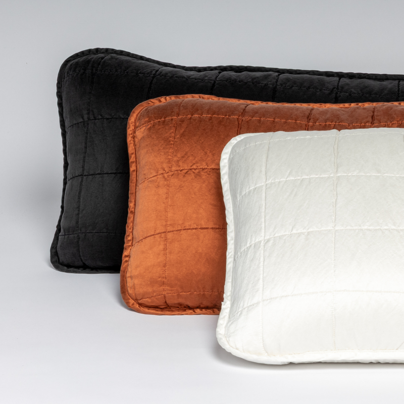 Sel Throw Pillow | Three rectangular quilted throw pillows stacked against each other on a white background, shot straight on.