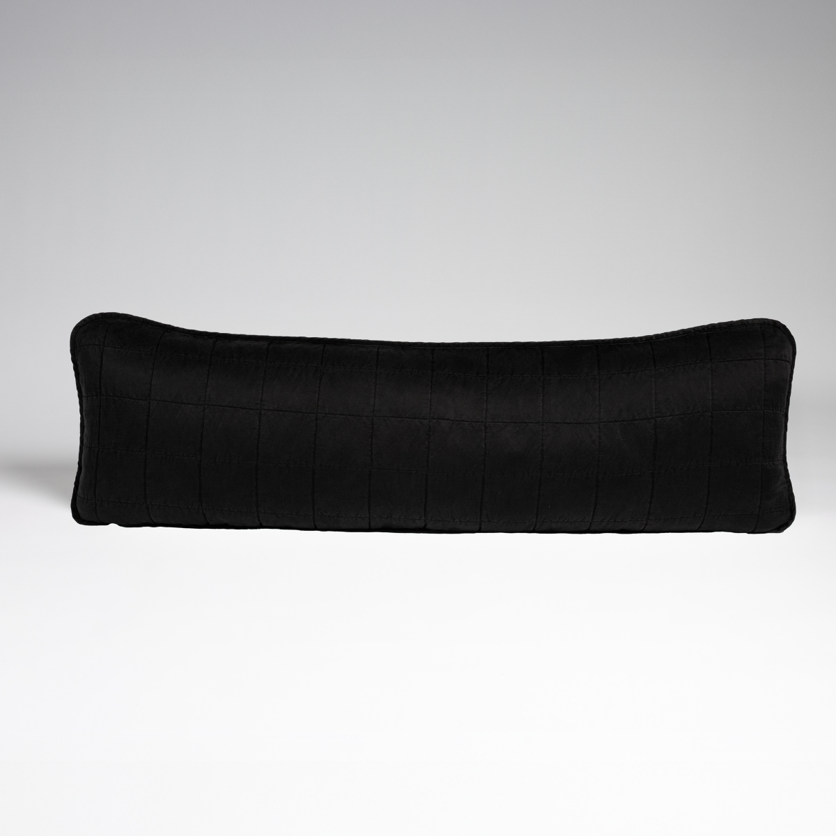 Sel Throw Pillow | Corvino | A straight-on shot of a square-quilted body pillow in corvino, our classic black, against a white background.
