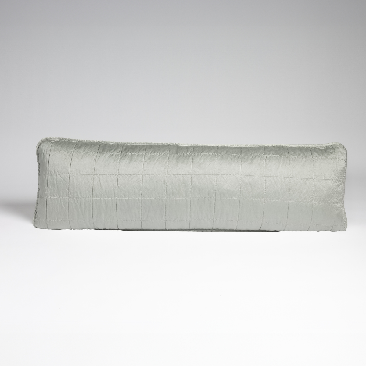 Sel Throw Pillow | Eucalyptus | A straight-on shot of a square-quilted body pillow in eucalyptus, a soft light green, against a white background.