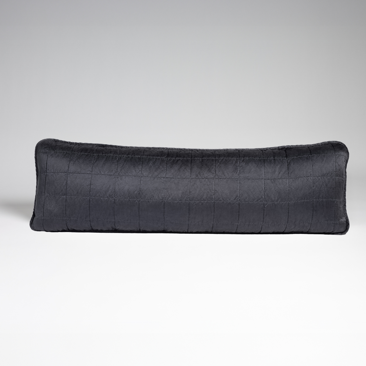 Sel Throw Pillow | Midnight | A straight-on shot of a square-quilted body pillow in midnight, a rich indigo tone, against a white background.