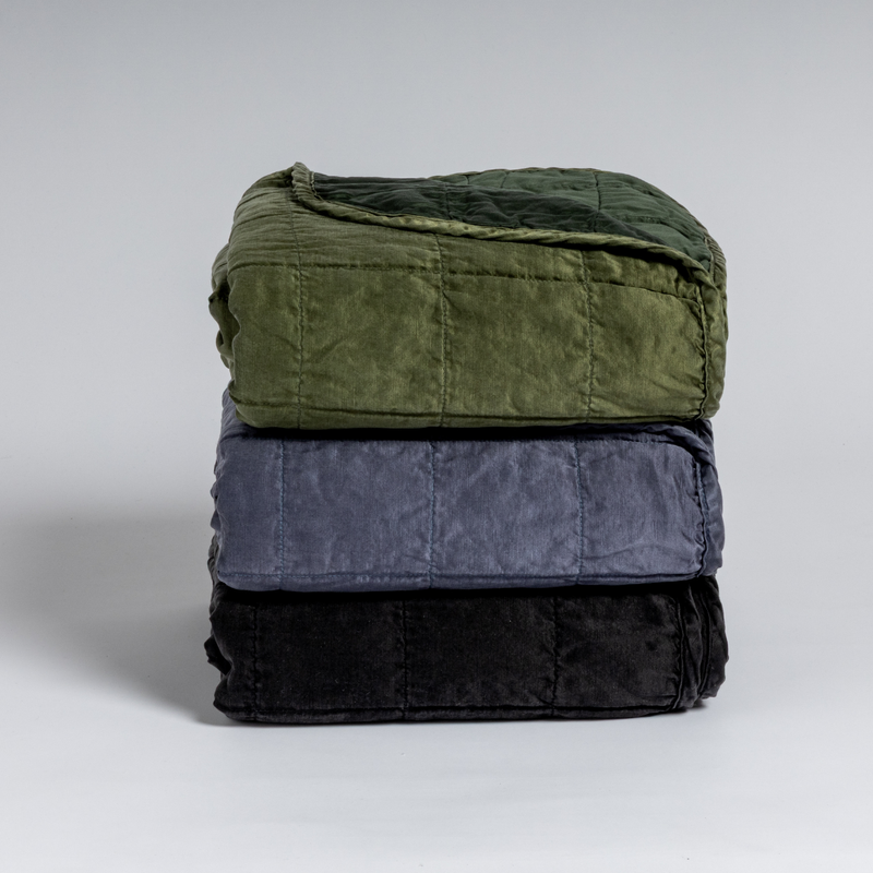 Sel Blanket | A stack of three square-quilted charmeuse blankets shot straight on against a white background. 