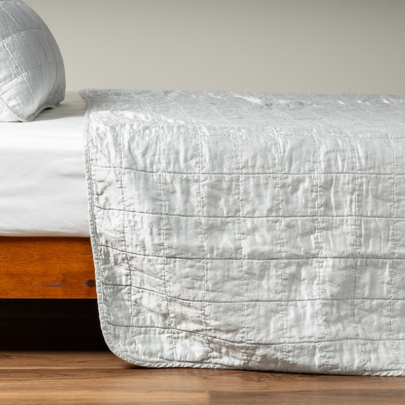Sel Coverlet | Cloud | A side shot of a square quilted charmeuse coverlet in cloud, a subtle sky blue-grey, with its matching sham.