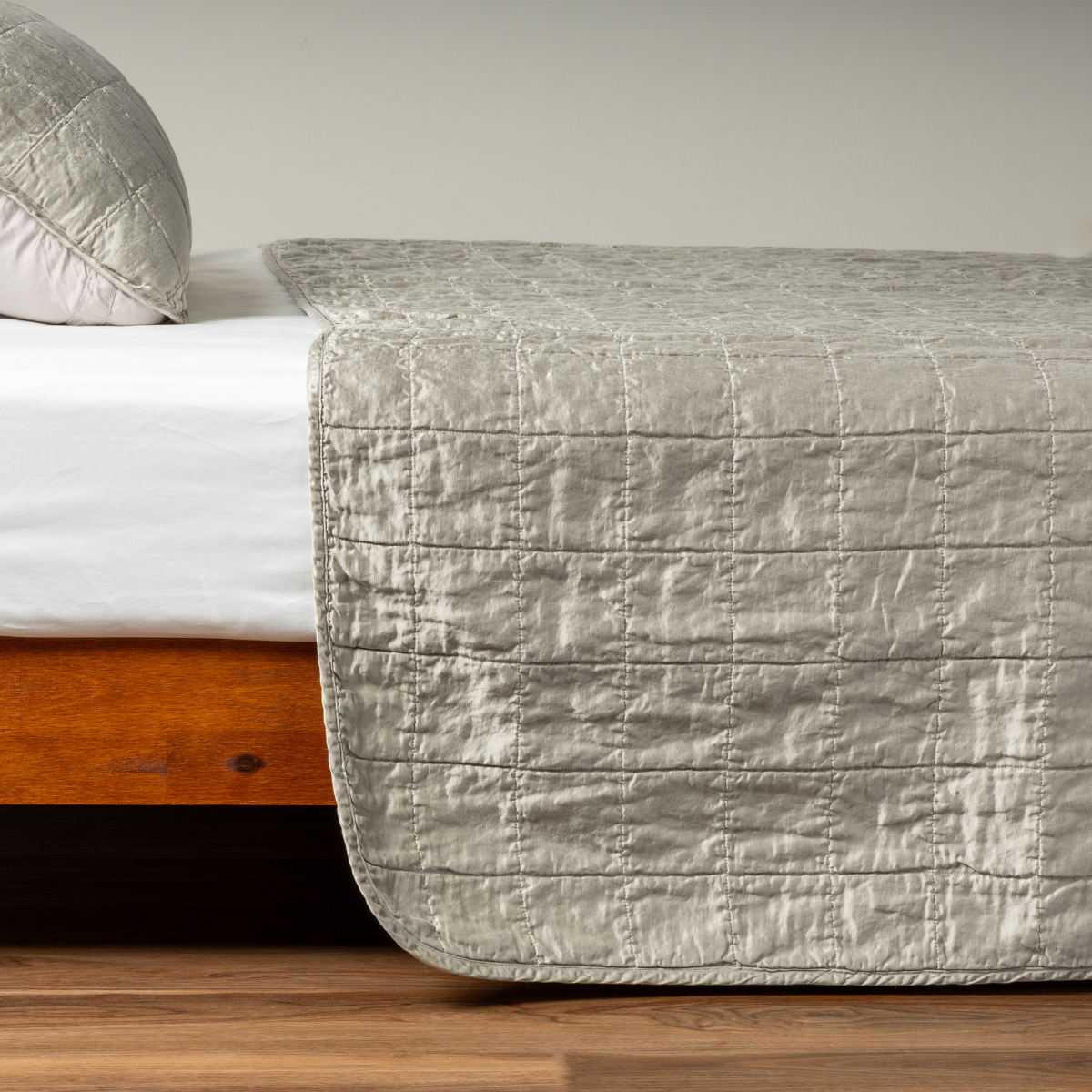 Sel Coverlet | Fog | A side shot of a square quilted charmeuse coverlet in fog, a soft mid-tone grey, with its matching sham.