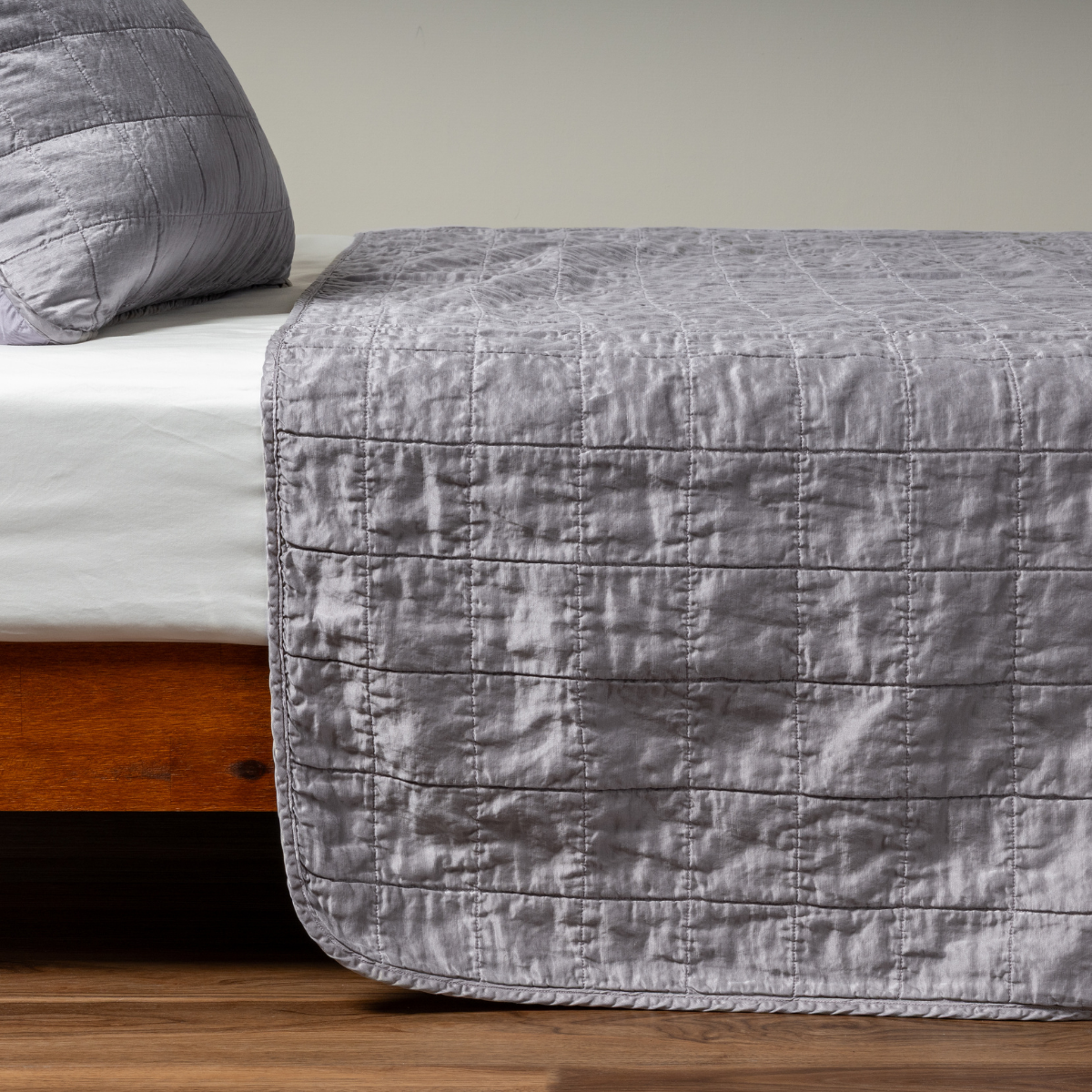 Sel Coverlet | French Lavender | A side shot of a square quilted charmeuse coverlet in french lavender, a neutral violet tone, with its matching sham.