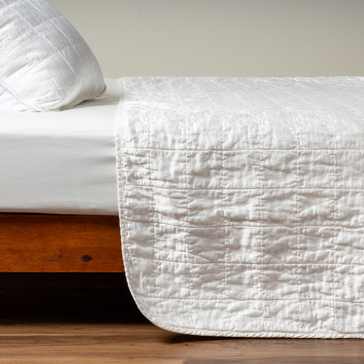 Sel Coverlet | White | A side shot of a square quilted charmeuse coverlet in classic white with its matching sham.