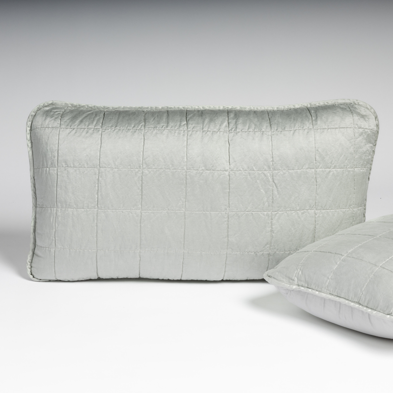 Sel Sham | Cloud | A pair of shams in cloud, a subtle sky blue-grey, shown against a white background with one sham upright and the other on its side to show the cotton sateen back and square-quilted charmeuse front.
