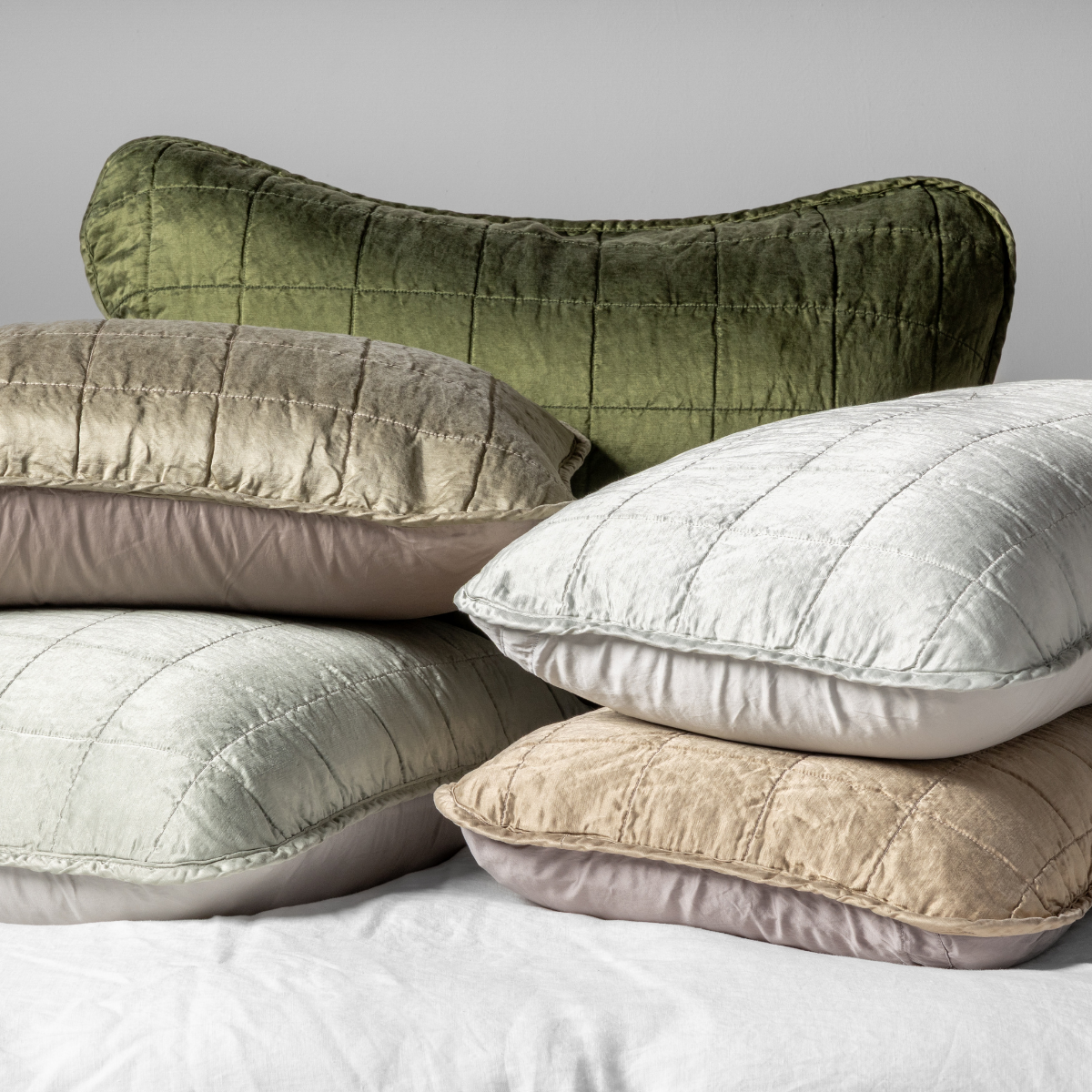 Sel Sham | A cluster shot of five square-quilted charmeuse shams showing their unquilted cotton sateen back.