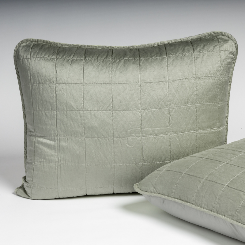 Sel Sham | Eucalyptus | A pair of shams in eucalyptus, a soft light green, shown against a white background with one sham upright and the other on its side to show the cotton sateen back and square-quilted charmeuse front.