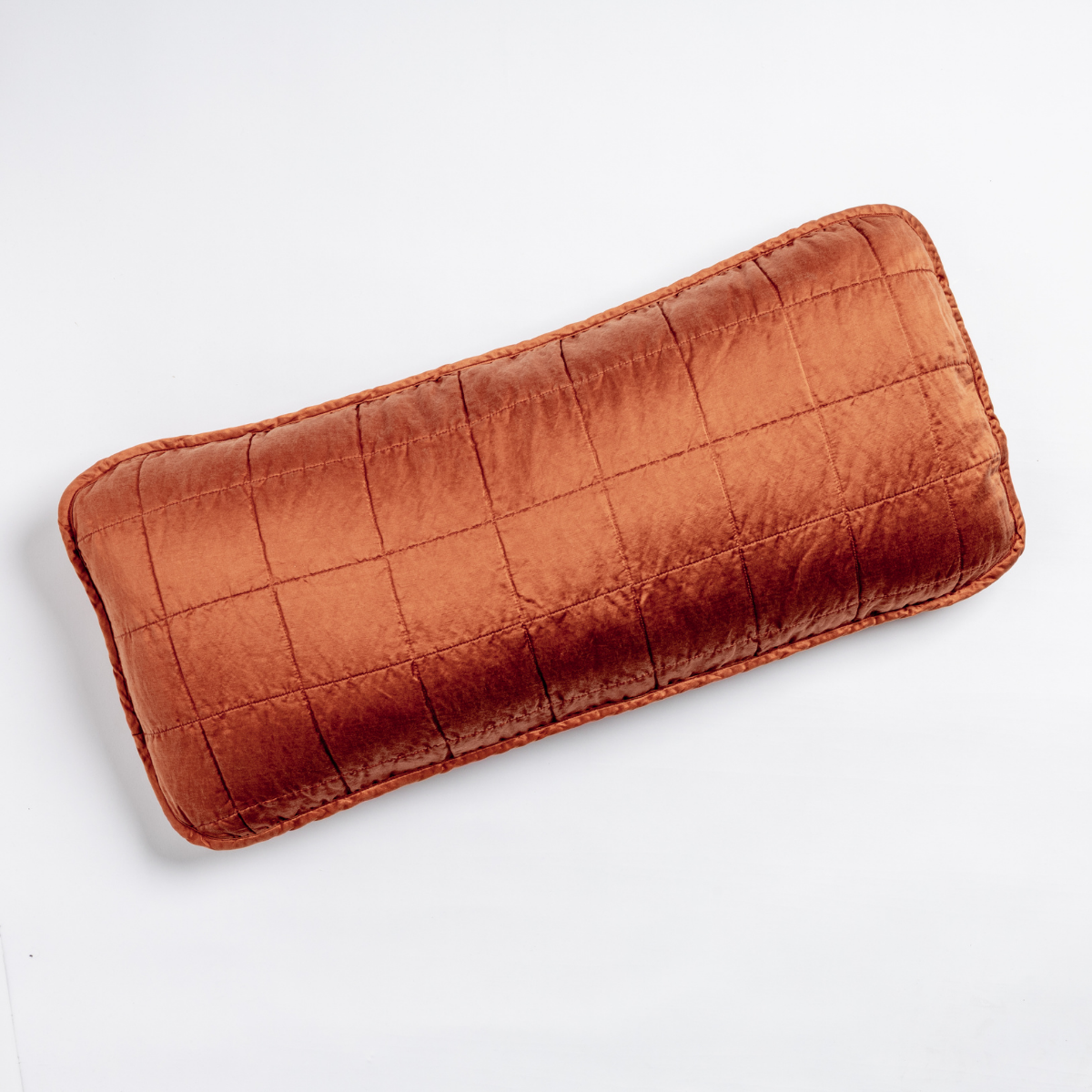 Sel Throw Pillow | Autumn | An overhead shot of a square-quilted rectangle throw pillow in autumn, a rich terracotta tone, against a white background.