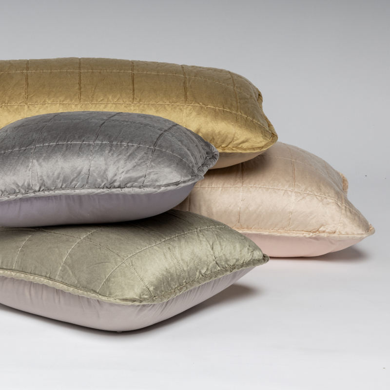 Sel Throw Pillow | A cluster shot of assorted square-quilted throw pillows shown straight on against a white background. 