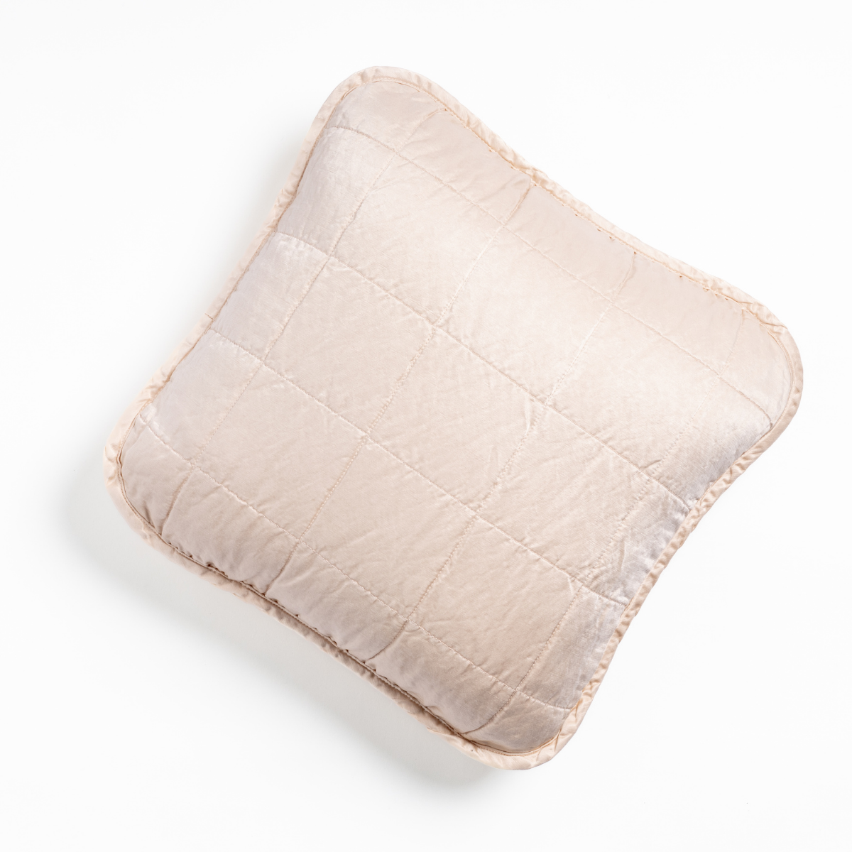 Sel Throw Pillow | Pearl | An overhead shot of a square-quilted square throw pillow in pearl, a soft rose pink tone, against a white background.