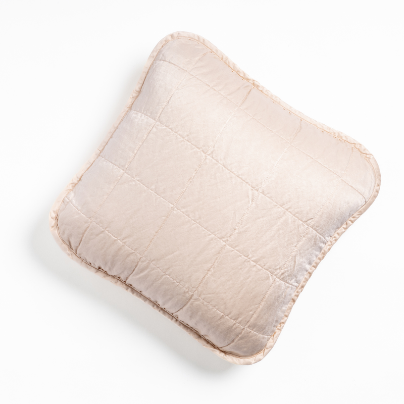 Sel Throw Pillow | Pearl | An overhead shot of a square-quilted square throw pillow in pearl, a soft rose pink tone, against a white background.