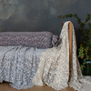 Allora Lace Throw Pillow | lace bolster cover on a bench with lace bed scarves against a limewash background.