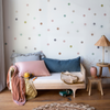Bria Crib Sheet | Crib sheet in parchment on a toddler bed with colorful pillows and blankets in a bright room with warm wood accents.
