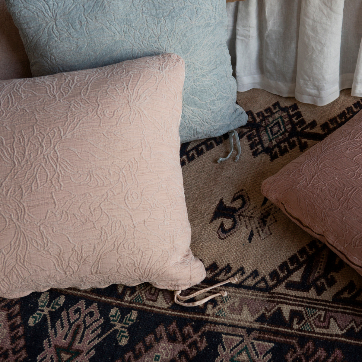 Georgia Throw Pillow | chenille and cotton jacquard throw pillows shown from overhead against a colorful rug