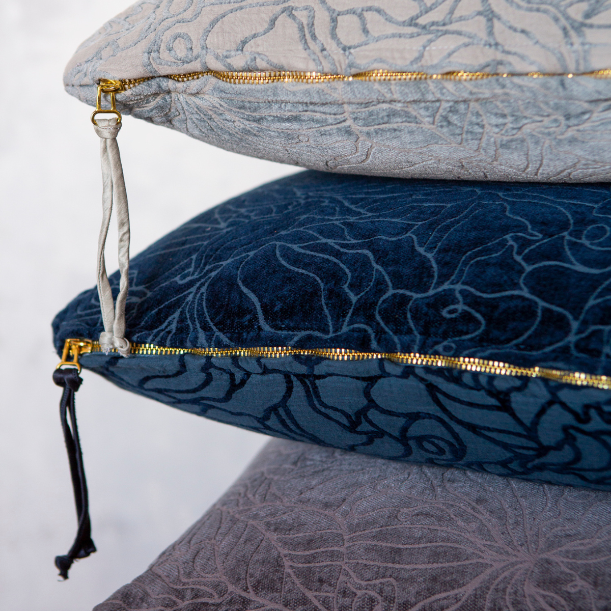 Georgia Throw Pillow | chenille and cotton jacquard throw pillows stacked and showing the detail of the textile as well as the dangling zipper pulls