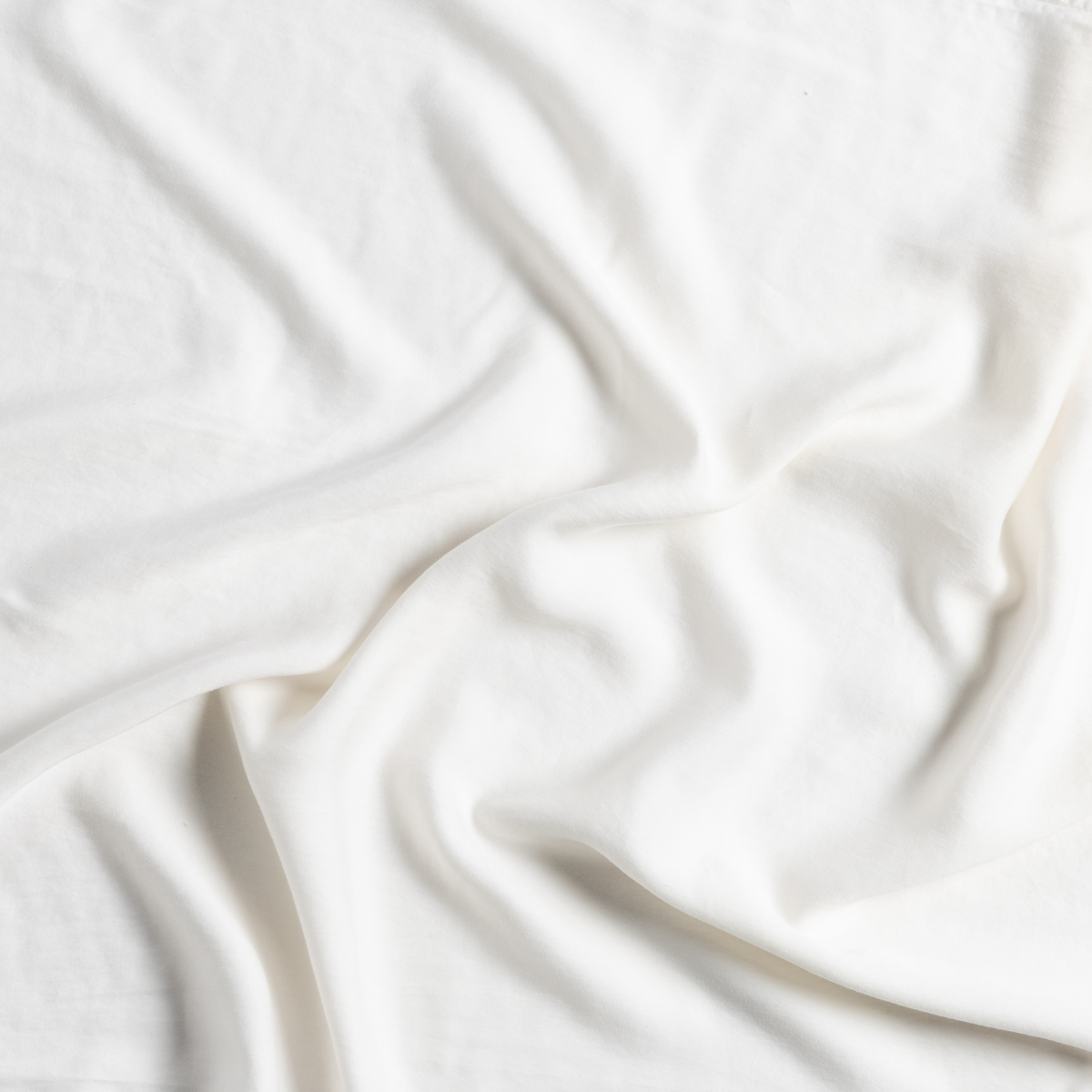 Madera Luxe Crib Sheet | Natural | a gently swirled piece of Tencel™ fabric in natural, a warm neutral.