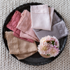 Austin Guest Towel | an overhead shot of folded midweight linen guest towels with banded edges with raw edges - shown with fresh flowers.