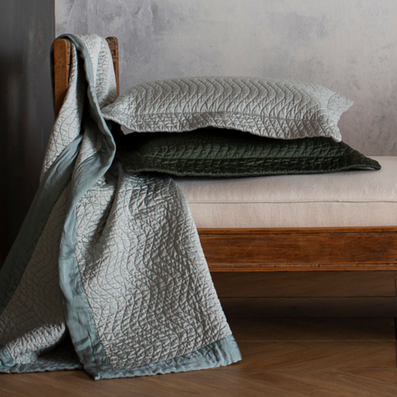 Cirillo Throw Pillow | pair of quilted cotton sateen throw pillows stacked on a daybed with matching throw blanket draped over its side.