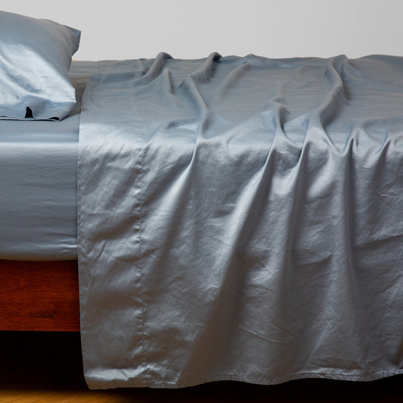 Bria Fitted Sheet | Tahoe Blue | Cotton sateen fitted sheet shown with matching flat sheet and sleeping pillow - side view.