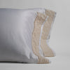 Bria Pillowcase (Single) | A pair of white cotton sateen pillowcases with a band of cotton lace on the cuff, standing upright against a white background.