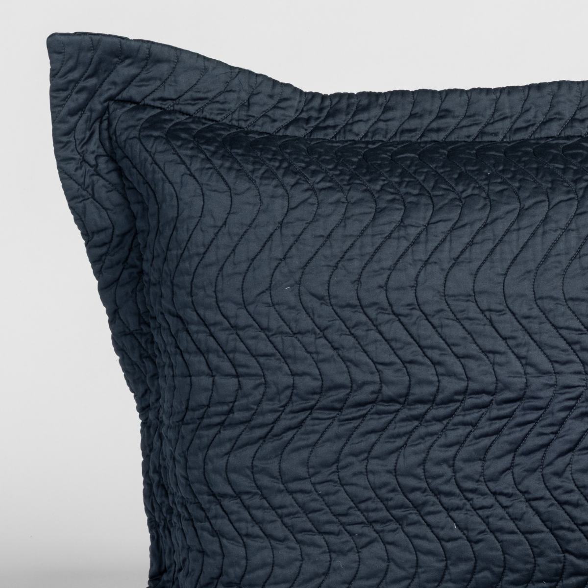 Cirillo Throw Pillow | Slate | close-up of a cirillo sham corner in slate, a polished dusky dark blue, against a plain white background.